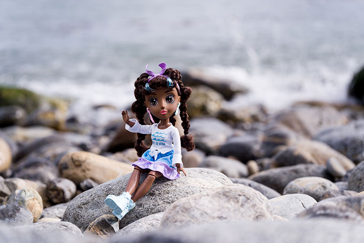 Koral of the B-Kind Dolls sitting on rocks near the ocean