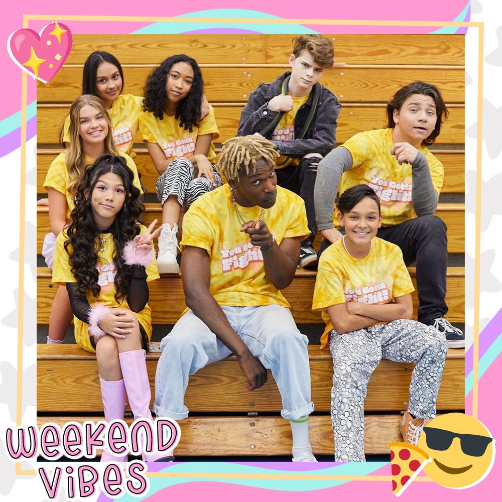 The cast of Mani wearing matching yellow shirts, sitting on gymnasium bleachers