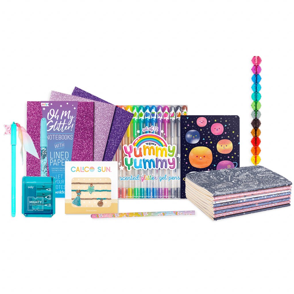 Product photo of the Stars and Shine Bonus Box from OOLY. Image features all of the products laid out together including journals, gel pens, mini-notebooks, charm bracelets, and more. They all have a celestial and sparkly theme.