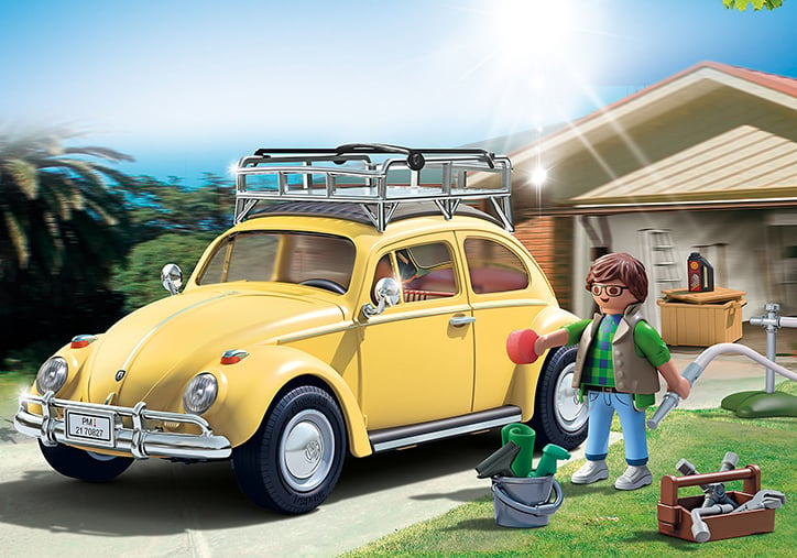 Lifestyle photo of the assembled Playmobil Volkswagen Beetle Special Edition build. The yellow car sits in a model driveway while the included figure uses the included carwashing accessories