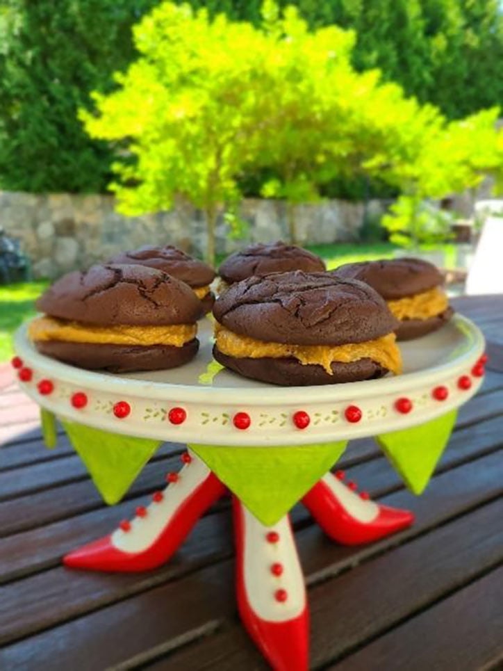 Homemade Whoopie Pies sitting on a decorative cake plate on an outdoor table